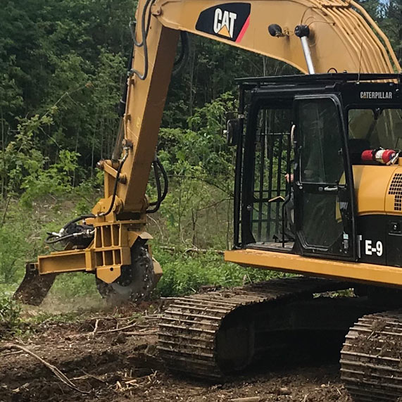 Large CAT Excavator Picking Up A Log For Land Clearing